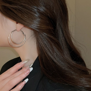 Close-up of elegant double hoop silver earrings worn by model for sophisticated style