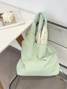 Mint green pleated popcorn textured tote bag on a clear chair for daily casual use