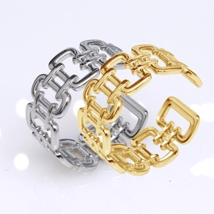 Close-up of gold and silver stainless steel rings with a unique chain link buckle design