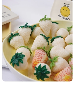 Macro shot of realistic pink and white strawberry charms in a yellow tray decoration