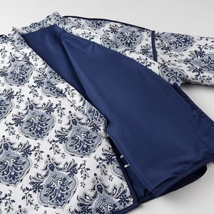 Detail of blue and white porcelain pattern jacket with solid blue lining and V-neck tie