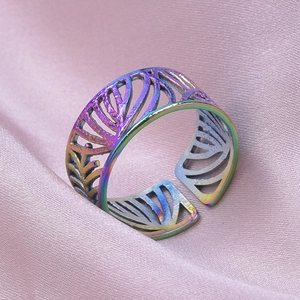 Vue macro d'une bague ajustable en acier inoxydable arc-en-ciel à motif de feuilles