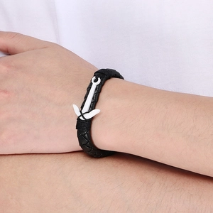 Close-up of black braided leather anchor bracelet with a white clasp on a male wrist