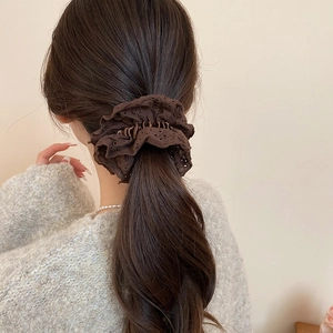 Detail of dark brown double-layer lace scrunchie worn on ponytail showing embroidery