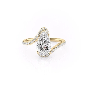 Pear shape drop zircon ring with halo setting and twisted gold band on white background