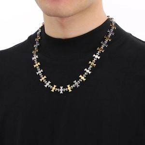 Detail of two-tone gold and silver cross chain necklace worn by a male model
