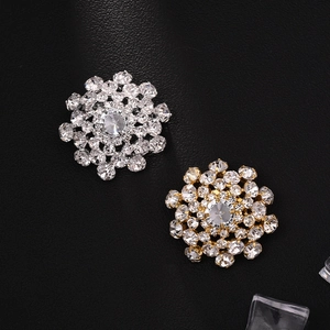 Detailed view of luxury snowflake brooches with crystals on a textured black background