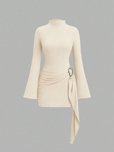 Détails des plis à la taille et boucle en métal argenté sur la robe crème