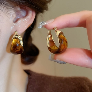 Detailed view of vintage amber resin U-shaped hoop earrings with gold metal clasp
