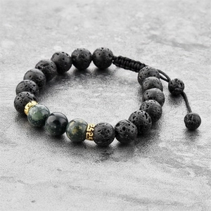 Détails macro de pierres de lave noires et pierres naturelles sur bracelet tissé