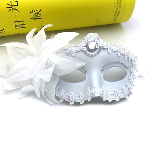 Close-up of white masquerade mask with lace, silver sequins, large silk flower and feathers