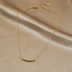 Gold-plated stainless steel necklace with sparkling diamonds on champagne satin background