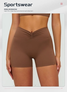Detail showing high-waisted yoga shorts with V-shaped waistband and model information