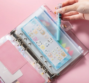 Macro detail of A6 PVC binder showing 6-hole zipper bags with cute cartoon stickers