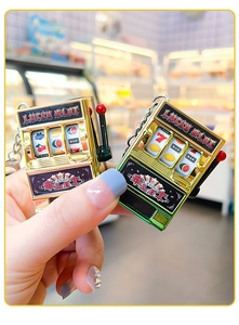 Detailed view of mini slot machine keychains in gold and green with movable levers