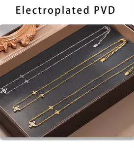 Detalle de collares de trébol en oro y plata chapados en PVD con circonitas en estuche