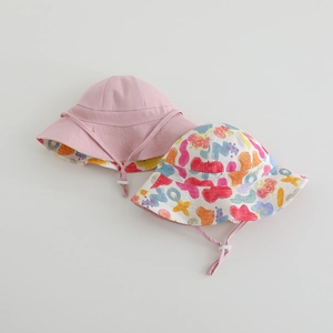 Detail of kids reversible sun hat with colorful graffiti pattern and windproof chin strap