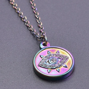 Gros plan d'un pendentif œil maléfique irisé orné de strass sur une chaîne assortie