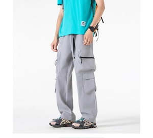Dettaglio dei pantaloni cargo grigi con ampie tasche laterali e coulisse nera in vita