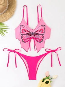 Detail of pink butterfly print bikini set with neck ties and tropical holiday props