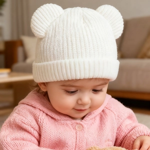 Close-up of white baby knitted beanie with cute bear ears and vertical ribbed texture