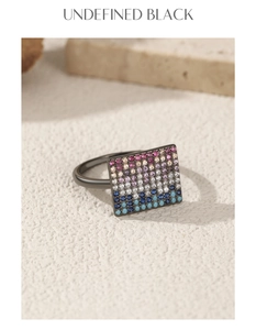 Macro view of pixel style ring with multicolor pavé set stones and dark metal finish