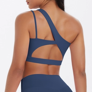 Detail of navy blue sports bra with asymmetric straps and a semi-circle back cutout design