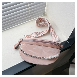 Detailed view of pink pleated crescent bag featuring wide shoulder strap and pearl chain