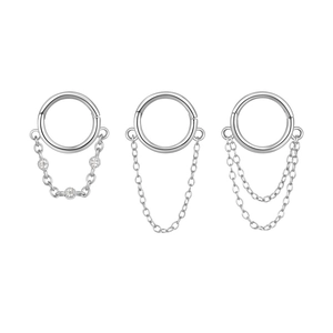 Dettaglio di tre anelli clicker in argento S925 con catene minimaliste e zirconi