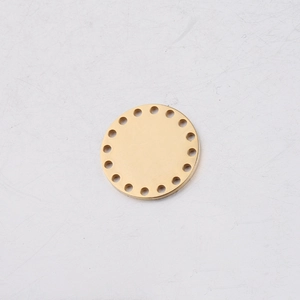 Detailed top view of gold stainless steel round charm with decorative edge holes