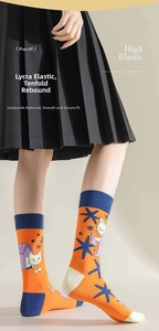 Detail showing bright orange asymmetric cotton socks with cute cartoon cat patterns and blue accents
