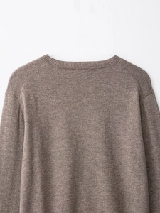 Detailed close-up of brown wool blend knit sweater crewneck and shoulder stitching