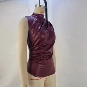 Detail of burgundy faux leather sleeveless top with high collar and asymmetric pleats