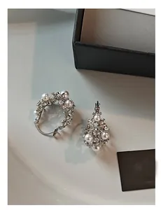 Detail view of silver hollow basket earrings with inlaid pearls and sparkling diamonds
