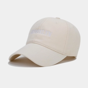 Detailed macro side view of Brooklyn 3D embroidery on a beige cotton baseball cap