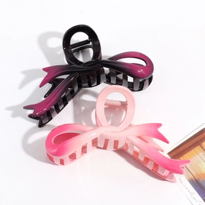 Detail of gradient butterfly hair claws in purple-black and pink resin with spring