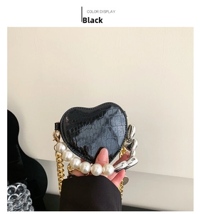 Détail du mini sac noir en forme de cœur avec texture croco et poignée en perles
