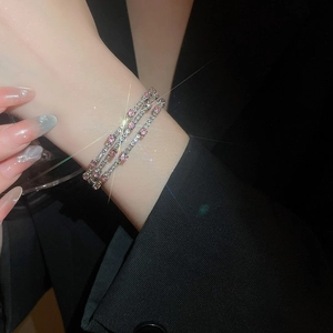 Detailed close-up of a triple-layered wrap bracelet featuring pink and clear cubic zirconia