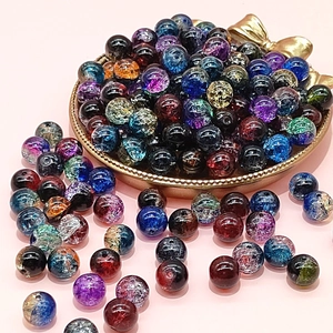 Colorful 10mm cracked glass beads for DIY jewelry making displayed on a gold tray