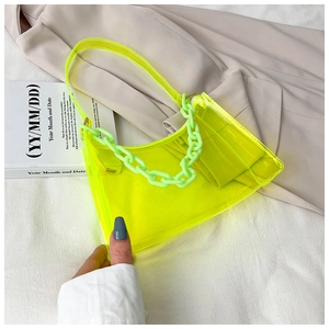 Détail du sac bandoulière en PVC jaune néon transparent avec chaîne en acrylique verte