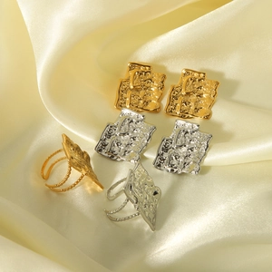 Gold and silver irregular square earrings and rings with lava texture on silk