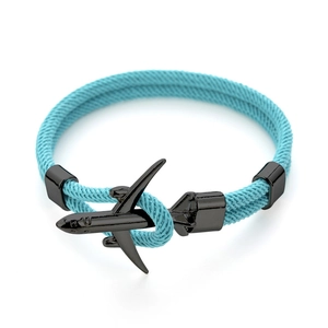 Dettaglio del bracciale in corda intrecciata turchese con ciondolo aereo in metallo nero