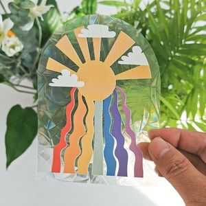 Rainbow suncatcher window film with sun and cloud design reflecting prismatic light