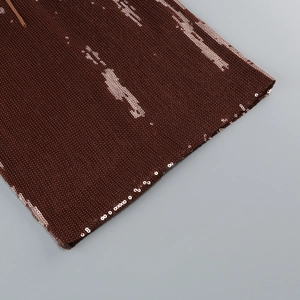 Detailed close-up of dark brown sequins with gold stripe texture on a slim party dress