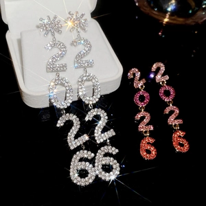 Vue macro de boucles d'oreilles pendantes 2026 serties de cristaux sur une boîte