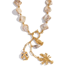 Detail view of baroque pearls with gold fish, shell, starfish and lobster charms
