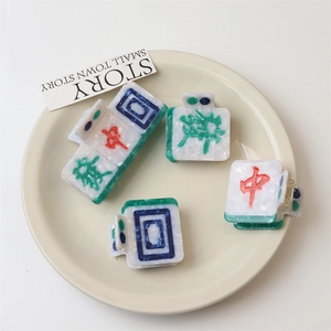 Detail of mahjong-themed hair claw clips with marble texture on a white tray