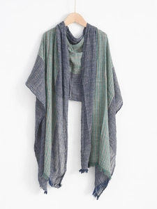 Detailed close-up of navy pinstripe scarf with fringe texture on a wooden hanger