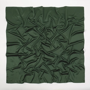 Detail of soft dark green satin silk square scarf with natural texture and elegant folds