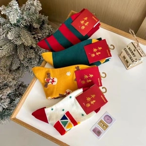 Vue détaillée de quatre chaussettes de Noël en coton aux motifs festifs d'élans et rayures